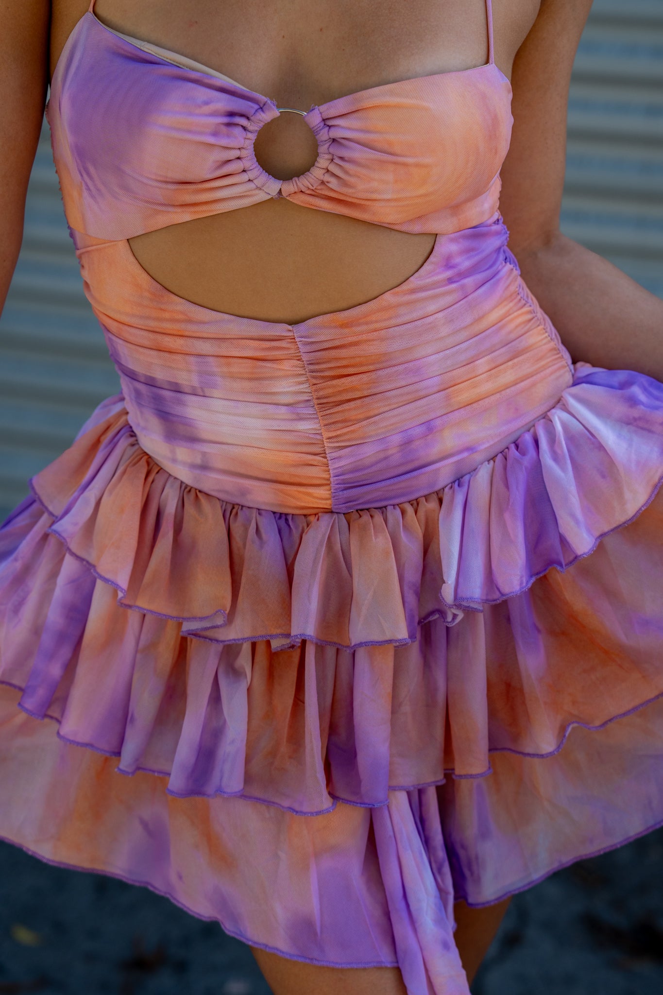 Float into festival season in this dream fairy enchanted pastel dress, blending purple and orange creating a sunset with riffle skirt and cut out details.